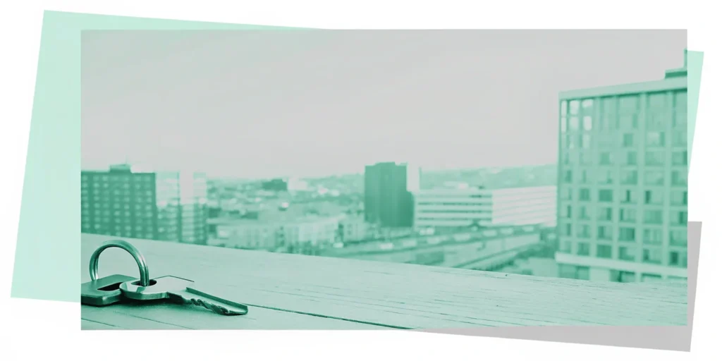 Keys on table. Cityscape view. Buy-to-let investment.